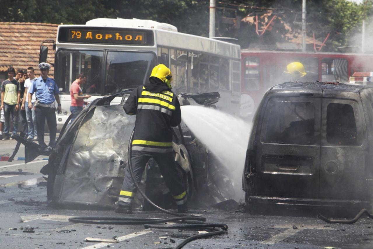 'A firefighter puts out a fire at the scene of a bomb attack in downtown Belgrade June 22, 2012. One person was killed and another was wounded when an unidentified perpetrator tossed an explosive devi