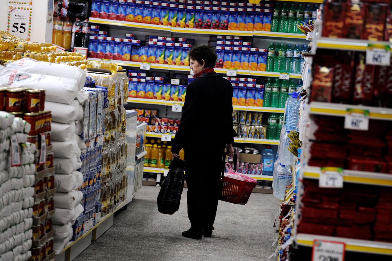 A woman looks at the price tags on merchandise in a government-backed discount supermarket in Belgrade on April 23, 2009. The Association of Free and Independent trade unions opened the another SOS shop with reduced prices and will open nine more SOS shop