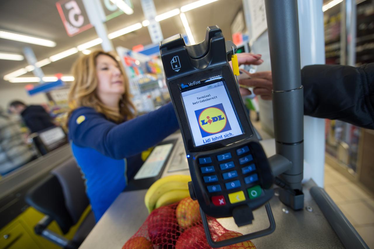 Staff member Violeta Greco sits at the cash register in a branch store of supermarket food discounter Lidl in Stuttgart, Germany, 3 March 2015. Photo: Marijan Murat/dpa/DPA/PIXSELL