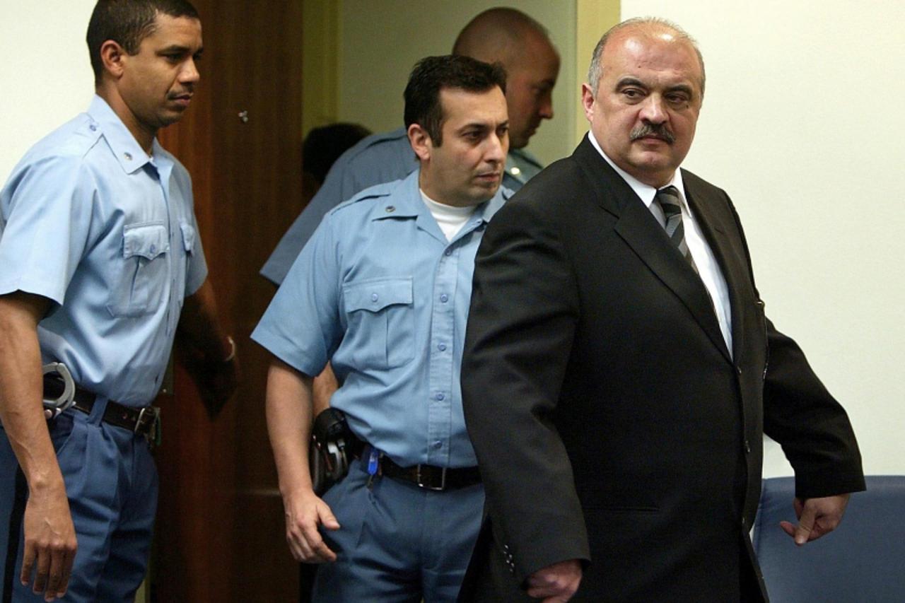 \'Retired Croatian general Ivan Cermak is flanked by United Nations security guards as he enters the courtroom prior to his initial appearance at the UN war crimes tribunal in The Hague, 12 March 2004