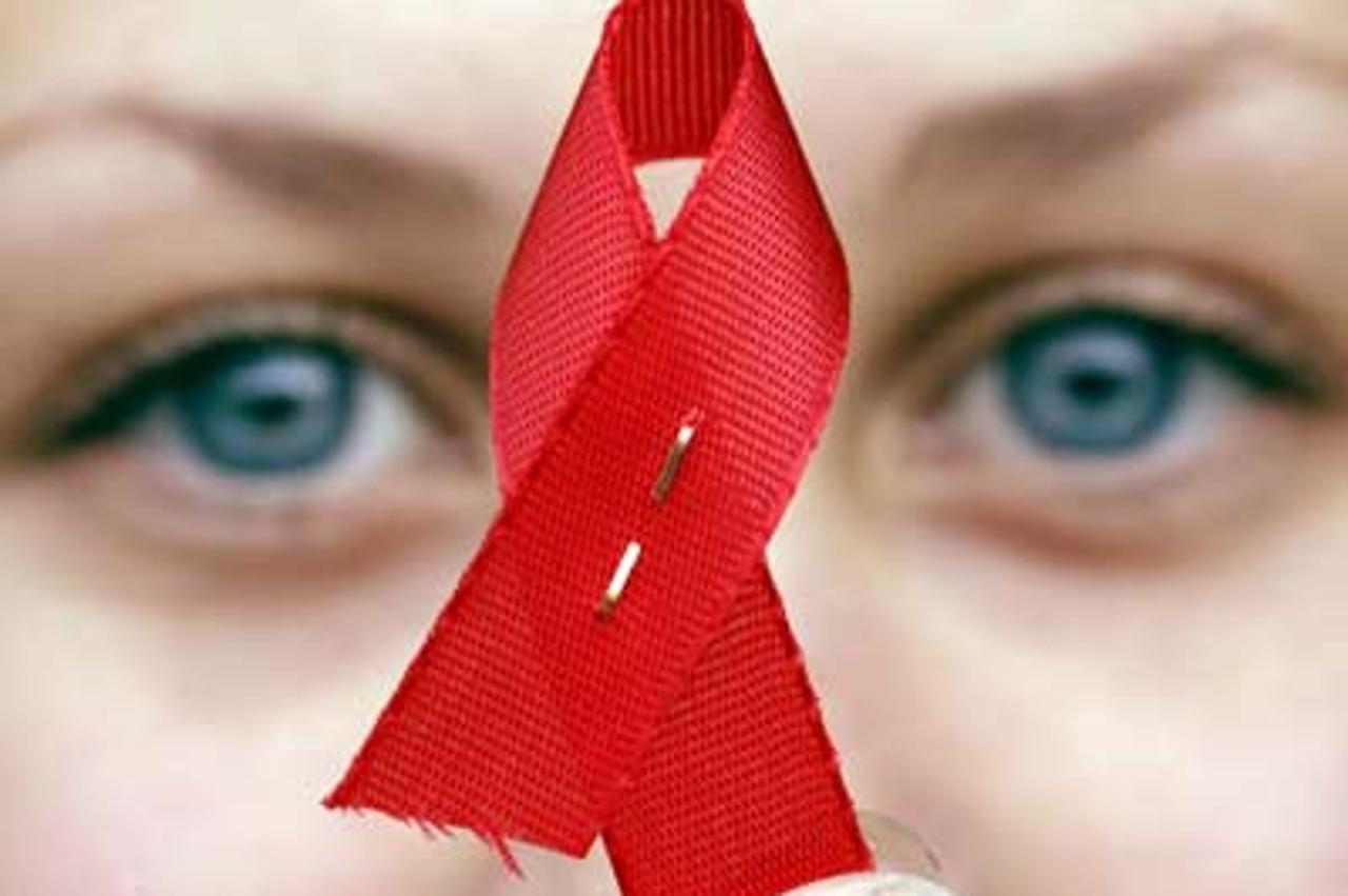'Eine Schülerin hält am Welt-AIDS-Tag eine rote Schleife in Villingen-Schwenningen in den Händen (Archivfoto vom 01.12.2003). Niemals zuvor hat sich das Aidsvirus so schnell verbreitet wie im Jahr 200
