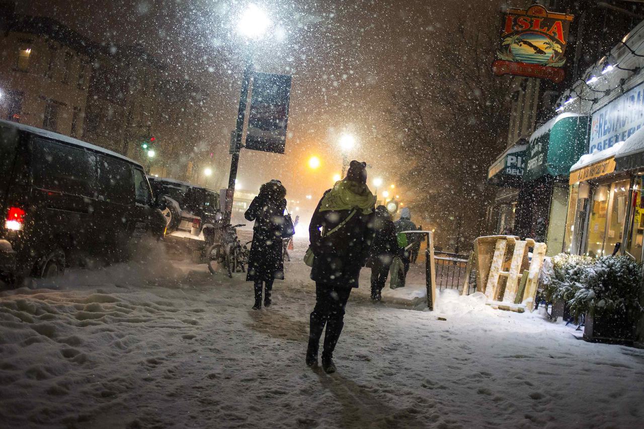 People walk through the snow in Hoboken, New Jersey January 21, 2014. A fast-moving cold front will plunge the U.S. Midwest into a deep freeze on Tuesday and dump up to a foot (30 cm) of snow on parts of the East Coast, forecasters said. REUTERS/Eric Thay