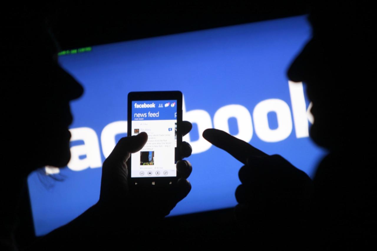 'A smartphone user shows the Facebook application on his phone in the central Bosnian town of Zenica, in this photo illustration, taken May 2, 2013.  Facebook Inc said its systems to remove hate speec