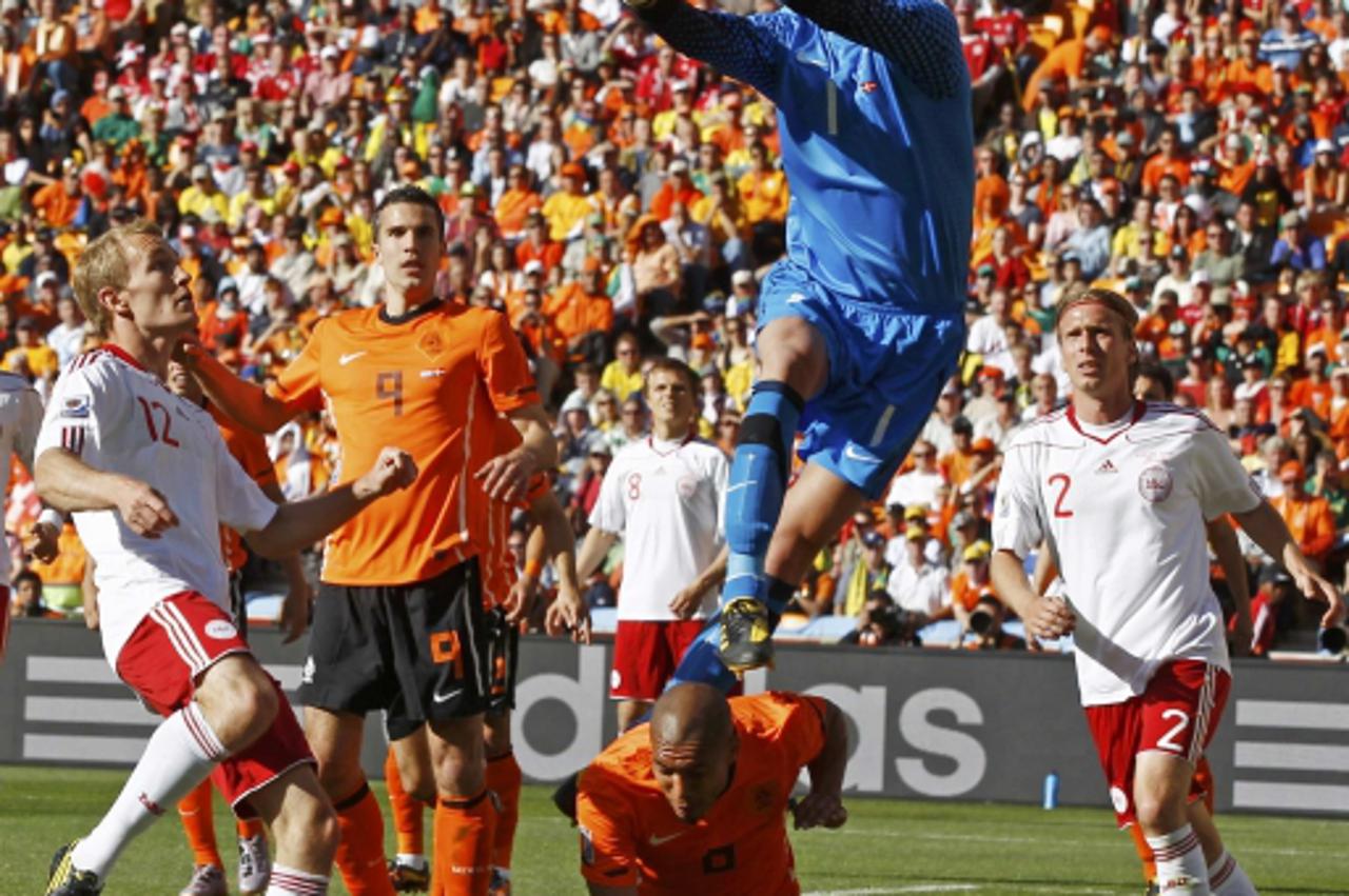 'Netherland\'s goalkeeper Maarten Stekelenburg jumps for the ball over team mate Nigel de Jong during during their 2010 World Cup Group E soccer match against Denmark at Soccer City stadium in Johanne