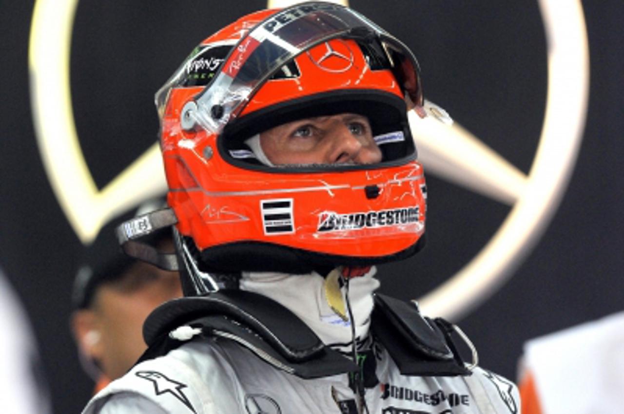 \'Mercedes driver Michael Schumacher of Germany reviews a race on a monitor as he gets ready in the pit during the second practice session at the Korean International Circuit for Formula One\'s Korean