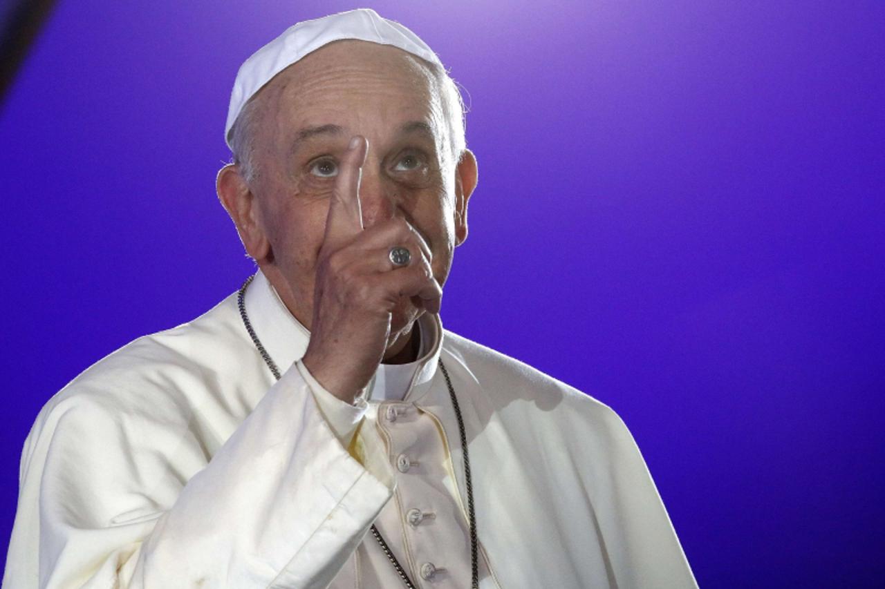 'Pope Francis looks up as he points to the rain on a stage during the Catholic Church's World Day of Youth at Copacabana beach in Rio de Janeiro, July 25, 2013. Pope Francis is on the fourth day of h