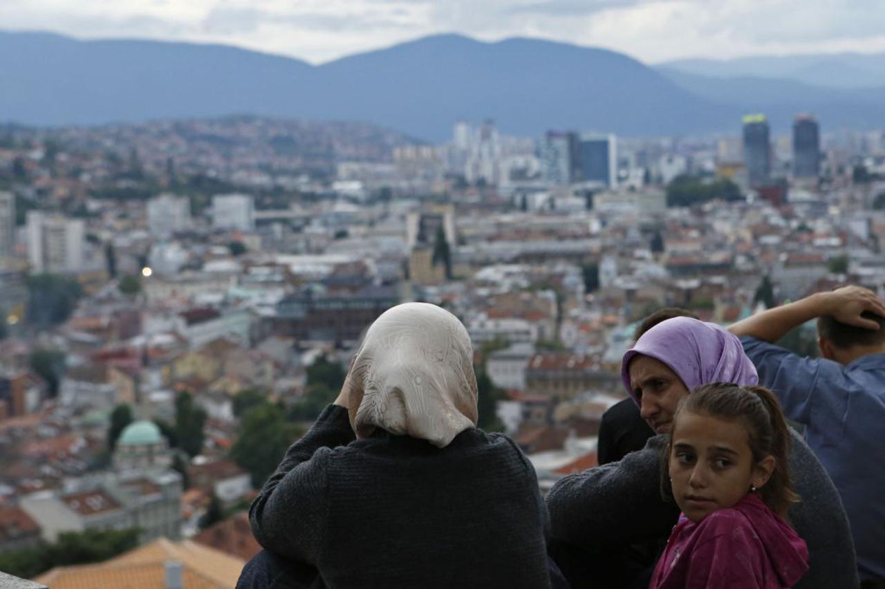 In this photo taken on Tuesday, July 15, 2014 a group of Bosnian Muslims are seen on top of an old fortress overlooking Sarajevo waiting for the city's minarets to light up signaling the end of the daytime Ramadan fast. The old fortress overlooking the hi