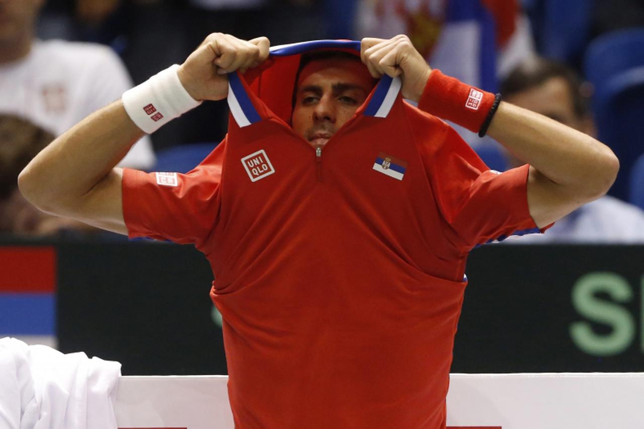 'Serbia\'s Novak Djokovic takes off his shirt during their Davis Cup quarter-final tennis match against John Isner of the U.S. in Boise, Idaho April 5, 2013. REUTERS/Jim Urquhart (UNITED STATES - Tags