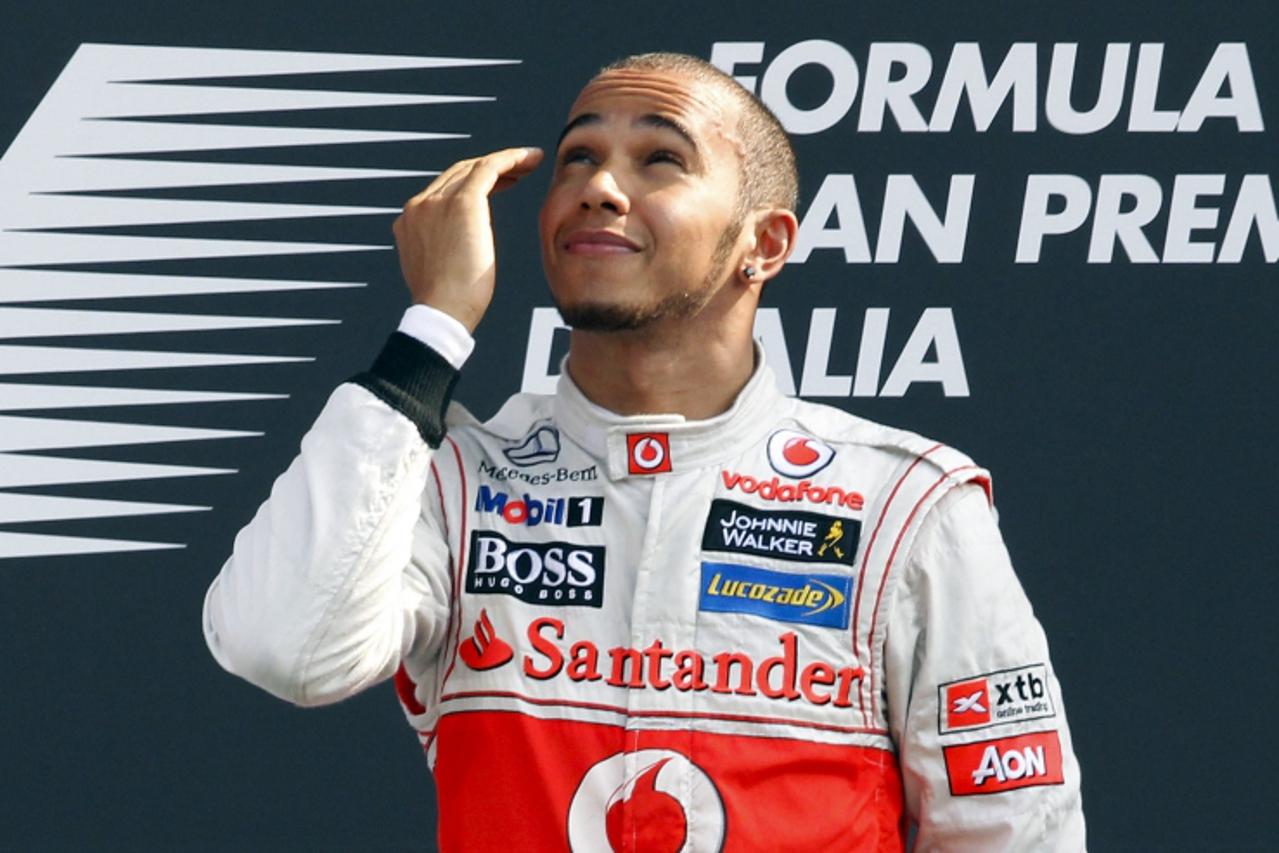 'McLaren Formula One driver Lewis Hamilton of Britain reacts as he celebrates on the podium after winning the Italian F1 Grand Prix at the Monza circuit September 9, 2012.  REUTERS/Giampiero Sposito (