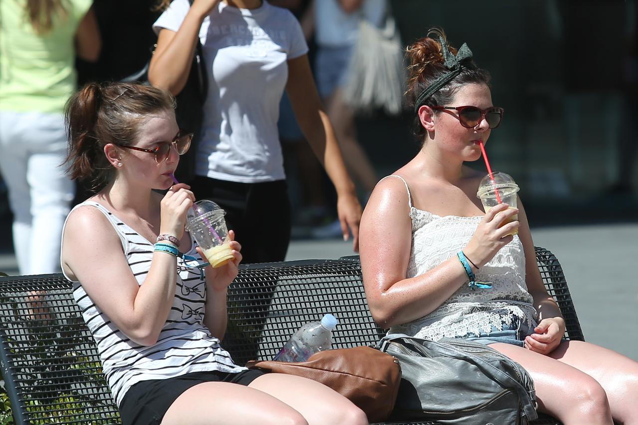 31.08.2015., Zagreb - Radi velikih vrucina i jakog sunca ova djevojka sjedeci s prijateljicom na Cvjetnom trgu odlucila se namazati kremom za suncanje i tako iskoristiti klupu i uz osvjezavajuce pice osuncati se na zagrebackoj spici.  Photo: Sanjin Struki