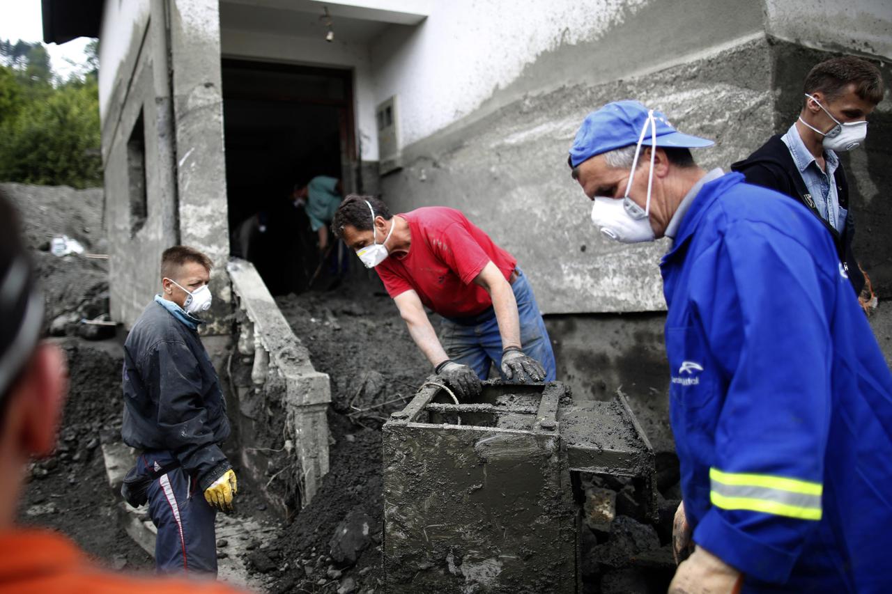 Members of the Kovacevic family remove a flood-damaged electric stove from their home in Topcic Polje, May 31, 2014. More than 50 people were killed by flooding and landslides in Serbia, Bosnia and Croatia. The heaviest rainfall in more than a century had