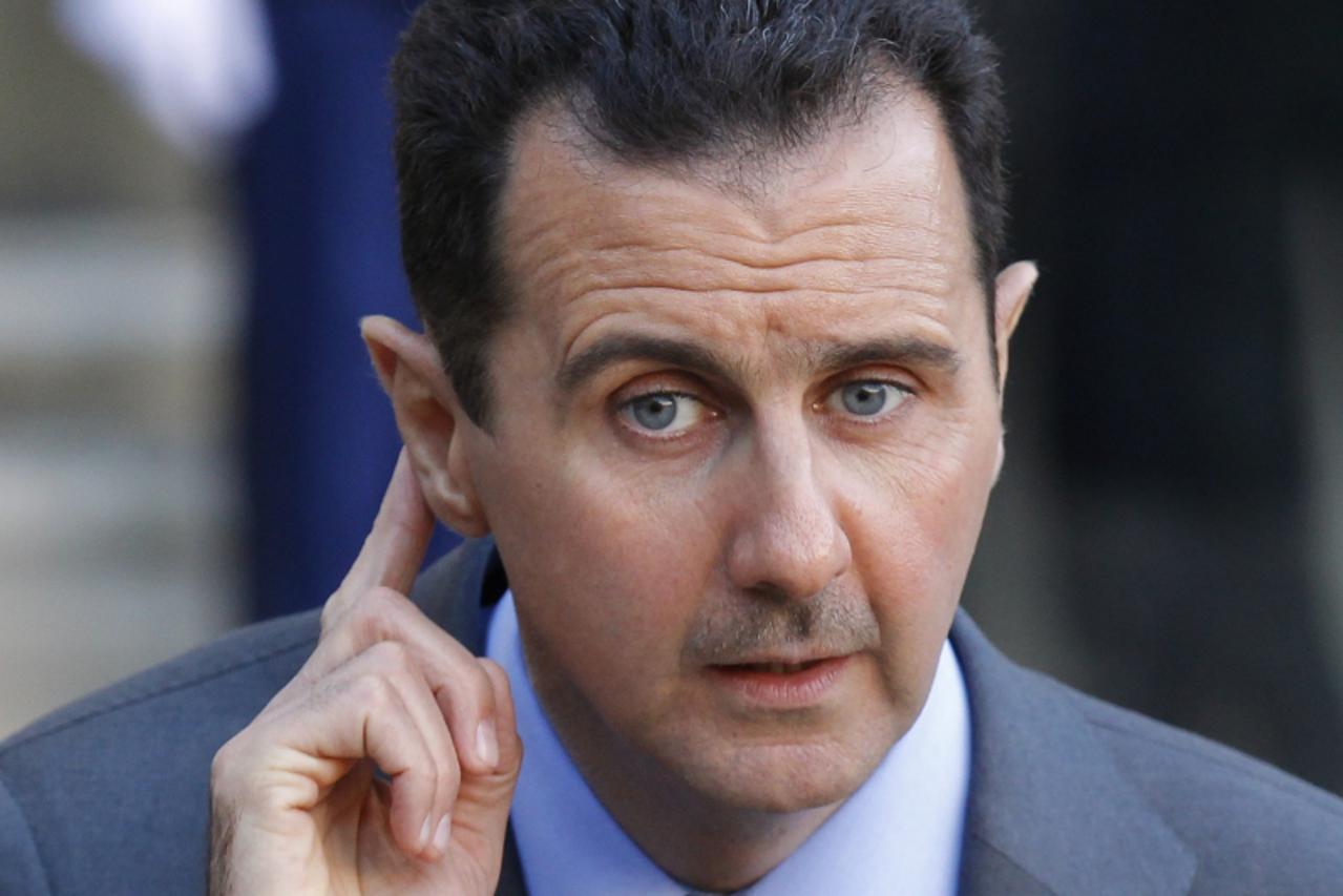 'Syria\'s President Bashar al-Assad listens to questions from journalists in Paris, in this December 9, 2010 file picture. The United States will impose sanctions on Assad for human rights abuses on M