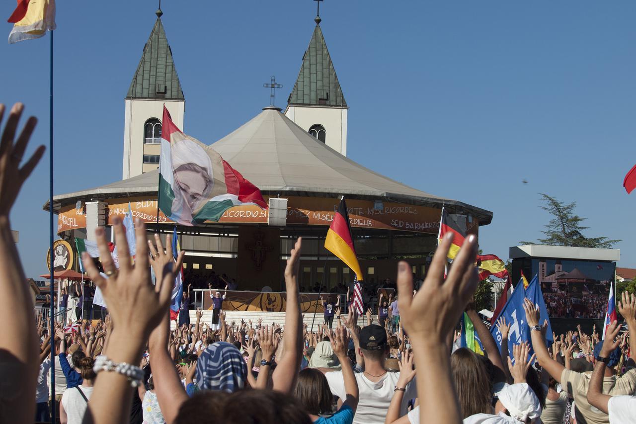 Mladi s rukama u zraku za vrijeme nastupa medjunarodnog zbora i orkestra koji čini 20 zemalja. Medjugorje, 05.08.2016.Snimio. marijan Sivrić