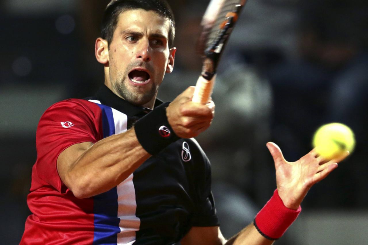 'Novak Djokovic of Serbia returns the ball to Bernard Tomic of Australia during their match at the Rome Masters tennis tournament May 15, 2012. REUTERS/Max Rossi (ITALY - Tags: SPORT TENNIS)'