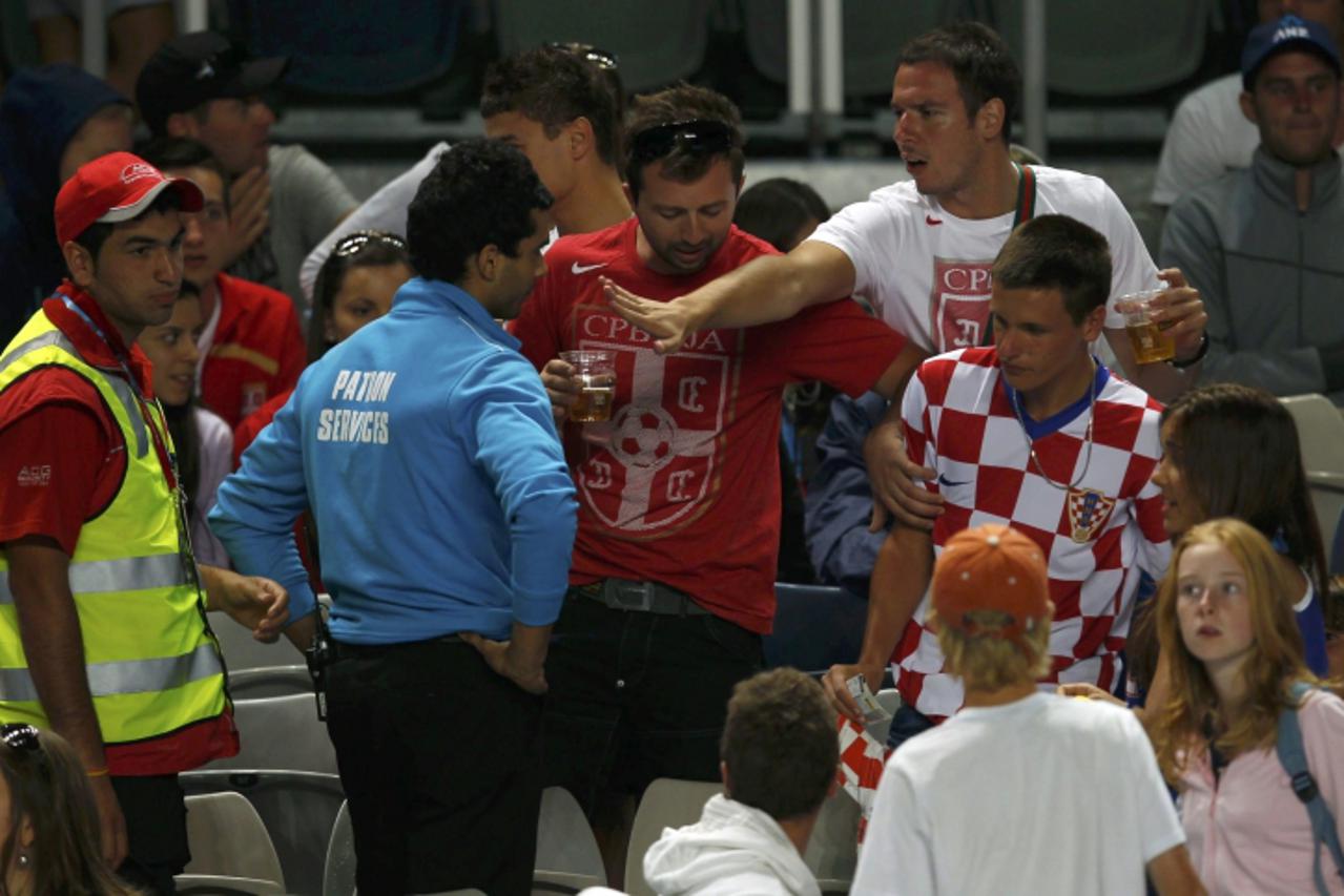\'Security speak to fans during the match between Ivan Dodig of Croatia and Novak Djokovic of Serbia at the Australian Open tennis tournament in Melbourne January 19, 2011.         REUTERS/Petar Kujun