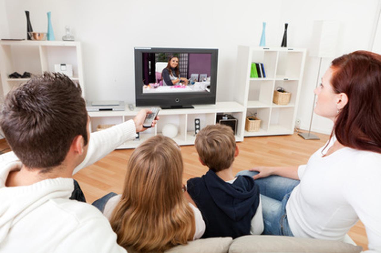 Young family watching TV together at home