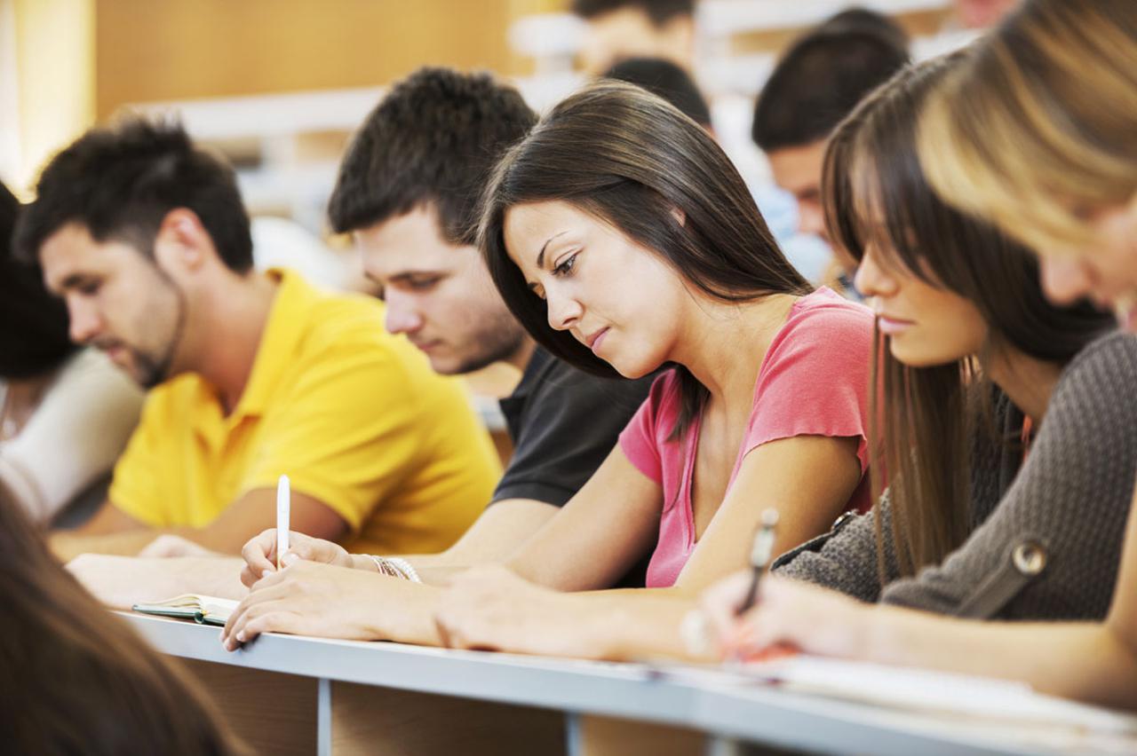 Group of college students in the university amphitheatre, they are sitting and doing an exam. The focus is on the girl in pink t-shirt.   [url=http://www.istockphoto.com/search/lightbox/9786738][img]http://dl.dropbox.com/u/40117171/group.jpg[/img][/url]