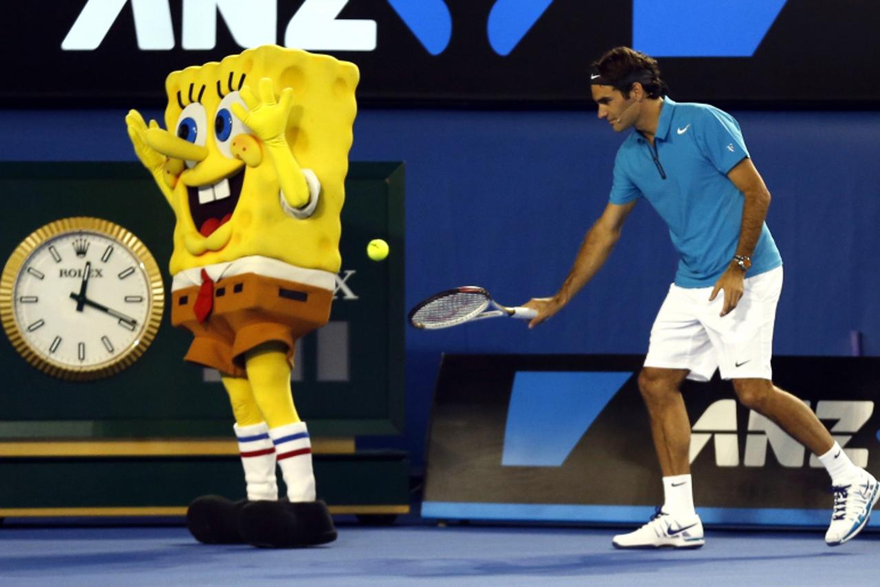 'Roger Federer of Switzerland hits a ball into the back of a man dressed as the cartoon character Sponge Bob Square Pants during Kids Tennis Day at the Australian Open tennis tournament in Melbourne, 