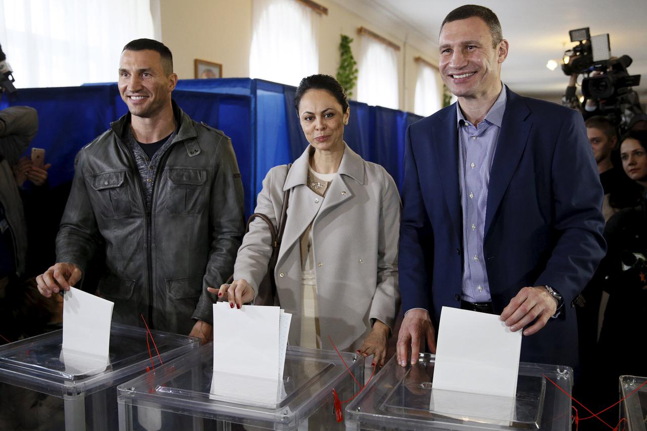 (R-L) Mayor of Kiev Vitaly Klitschko, his wife Natalia and his brother World heavyweight champion Wladimir Klitschko pose for a picture while casting their ballots during a regional election at a polling station in Kiev, Ukraine, October 25, 2015. Ukraini