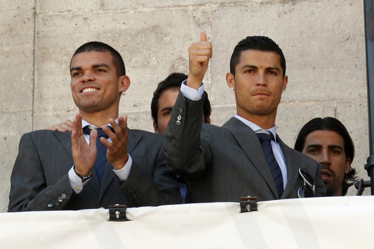 'Real Madrid players (L-R) Pepe, Gonzalo Higuain, Cristiano Ronaldo and Sami Khedira greet supporters from a balcony after their meeting with Esperanza Aguirre, President of Madrid regional government