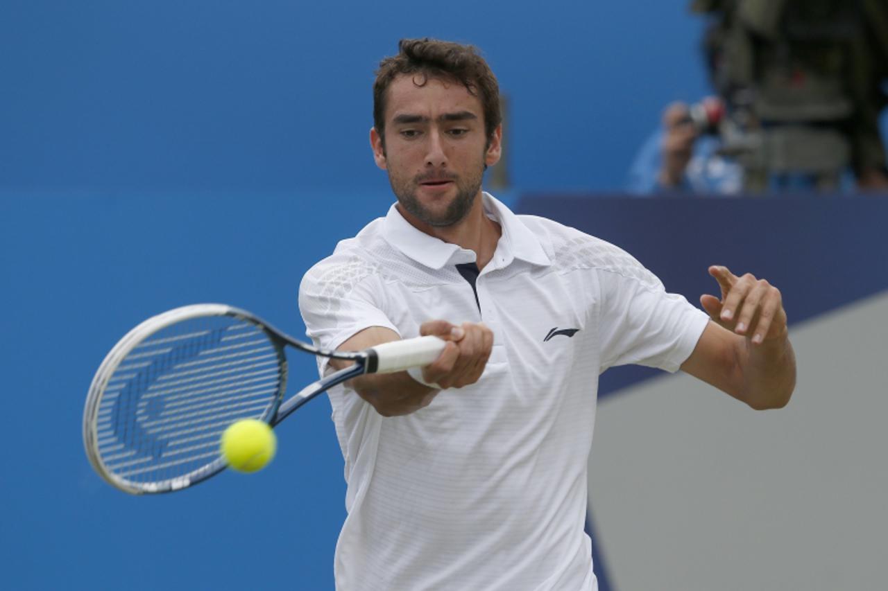 'Croatia\'s Marin Cilic hits a return to Britain\'s Andy Murray during their men\'s singles final tennis match at the Queen\'s Club Championships in west London June 16, 2013.   REUTERS/Eddie Keogh  (