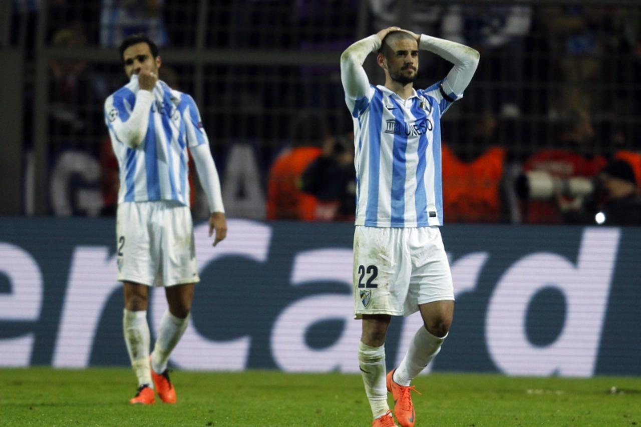 'Malaga's Isco (R) walks from the pitch dejected after defeat to Borussia Dortmund in the Champions League quarter-final second leg soccer match, in the western German city of Dortmund April 9, 2013.
