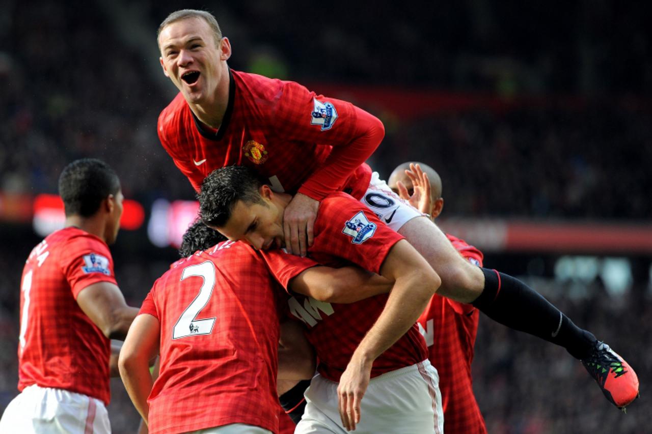 'Manchester United\'s English forward Wayne Rooney (up) celebrates after Dutch teammate Robin van Persie (C) scored during against Aresnal during their English Premier League football match at Old Tra