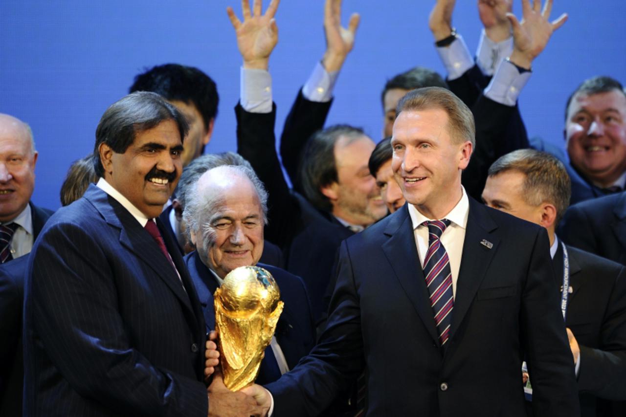 \'Qatar\'s Emir, Sheikh Hamad bin Khalifa al-Thani (L) and Russia\'s Deputy Prime Minister Igor Shuvalov hold the World Cup trophy behind FIFA presidentJoseph Sepp Blatter on December 2, 2010 at the F