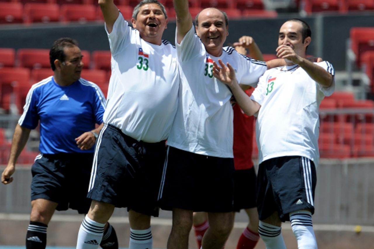 \'Chilean recently rescued miners Luis Urzua (L), Franklin Lobos (C) and Carlos Barrios (R), celebrate a goal against a team conformed by rescuers and government authorities, at the Estadio Nacional i