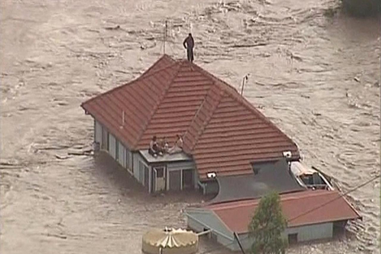 'People are seen on the rooftop of a house in Grantham, a township between Toowomba and Brisbane, in this still image taken from video January 10, 2011. Tsunami-like flash floods raced towards Austral