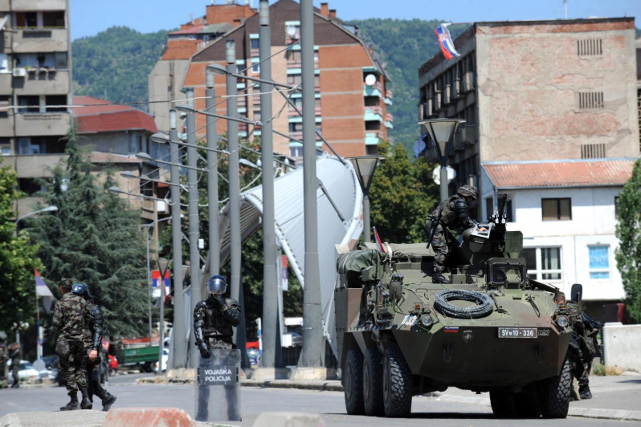 \'KFOR soldiers serving as part of the EU a peacekeeping mission in Kosovo guard the main bridge in the divided town of Mitrovica on July 28, 2011. Dailies report that Kosovo?s Prime Minister Hashim T
