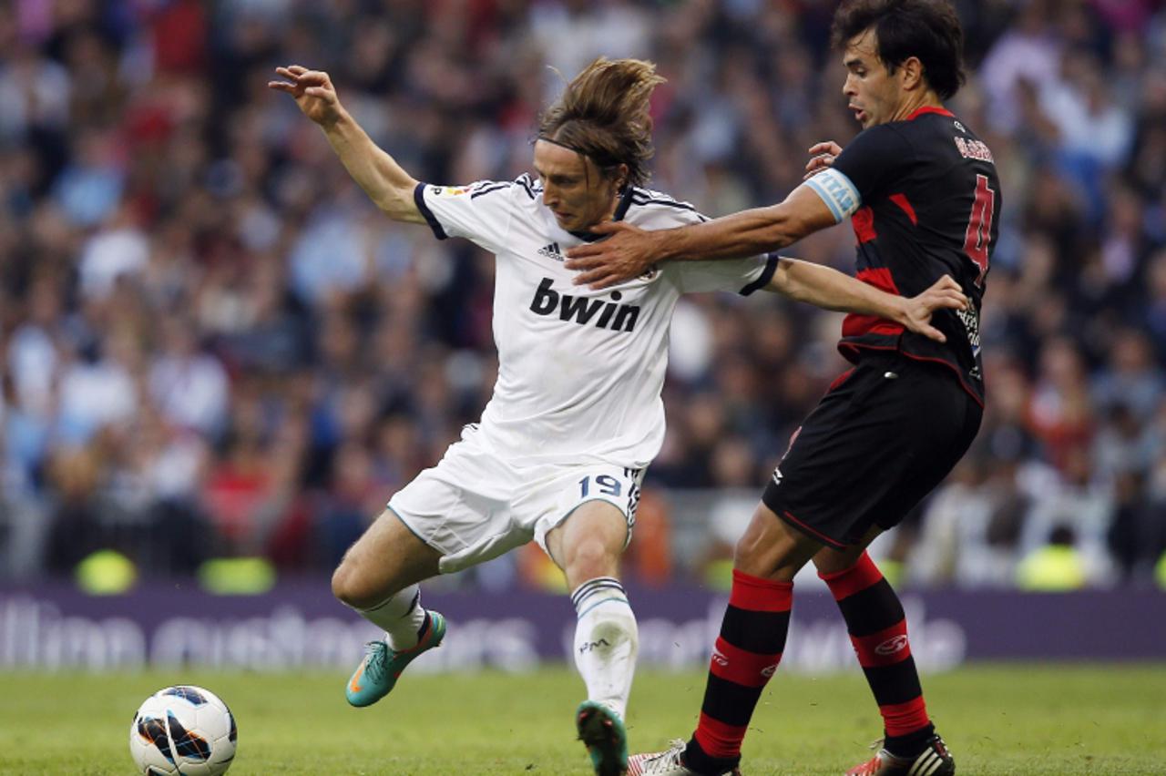 'Real Madrid's Luka Modric (L) fights for the ball with Celta Vigo's Borja Oubina during their Spanish First Division soccer match at Santiago Bernabeu stadium in Madrid October 20, 2012. REUTERS/Su