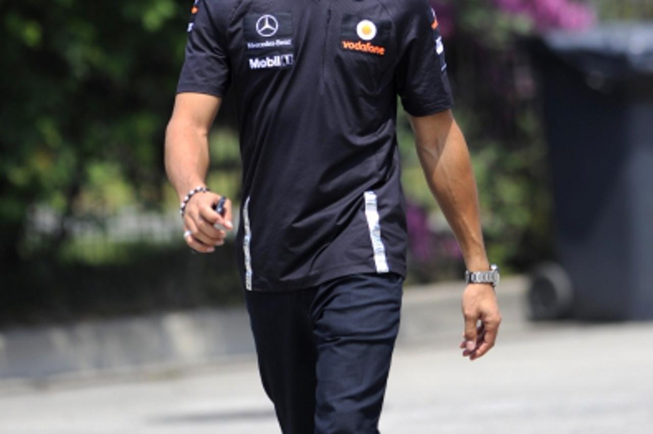 'McLaren-Mercedes driver Lewis Hamilton of Britain walks to the paddock before the race of the Formula One Chinese Grand Prix at in Shanghai on April 17, 2011. AFP PHOTO / LIU Jin'