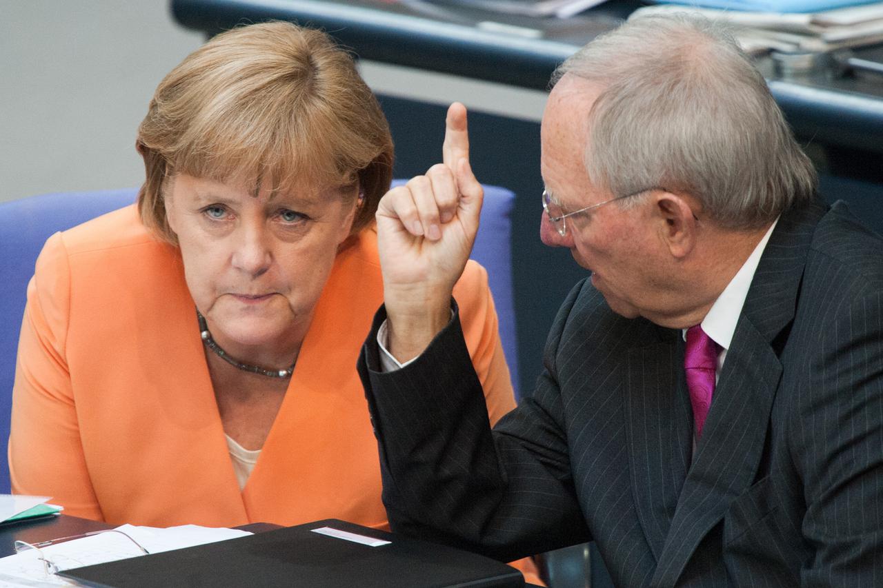 German Chancellor Angela Merkel (CDU) and German Minister of Finance Wolfgang Schaeuble (CDU) talk during a special session of the Bundestag in Berlin, Germany, 19 July 2012. Parliament will vote on helping Spanish banks with a credit of billions of euros