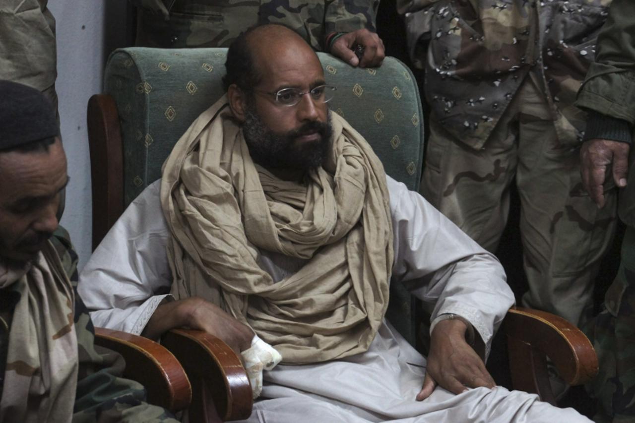 'Saif al-Islam is seen after his capture, in the custody of revolutionary fighters in Obari, Libya November 19, 2011. Libya\'s prime minister-designate said Saif al-Islam would receive a fair trial in