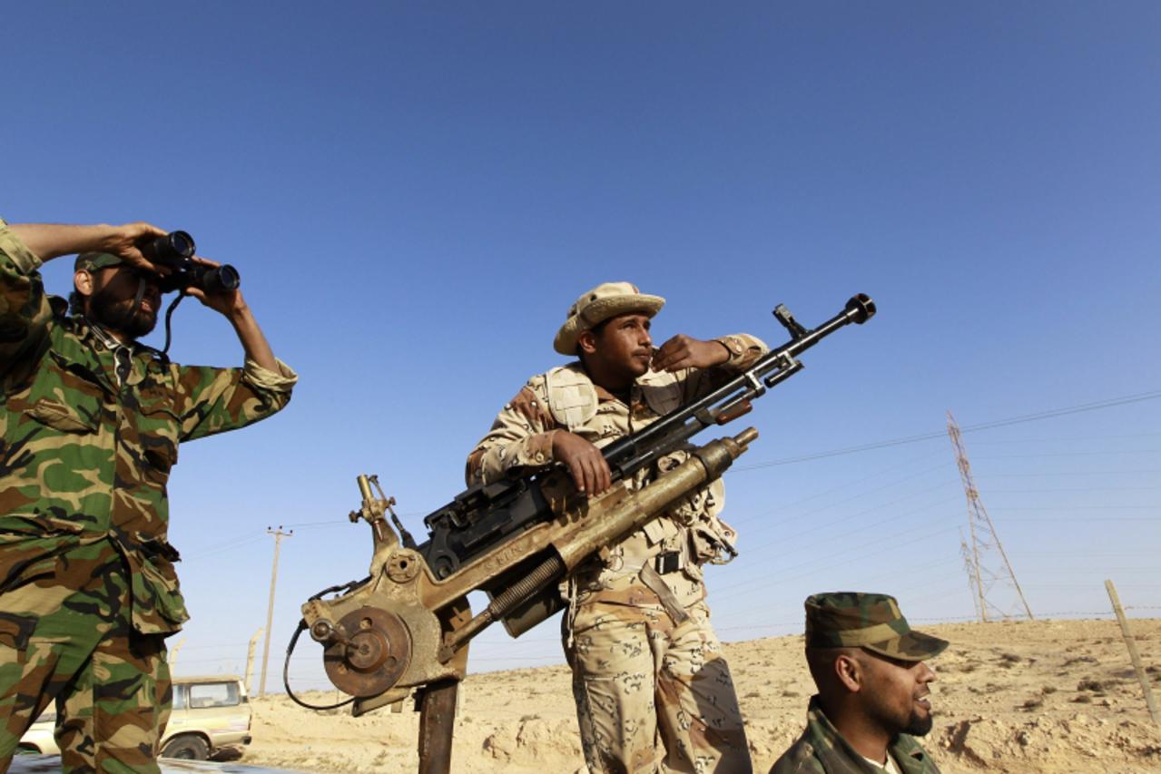 \'Rebel fighters stand around their vehicle at a staging area to the east of Brega April 5, 2011.    REUTERS Youssef Boudlal 