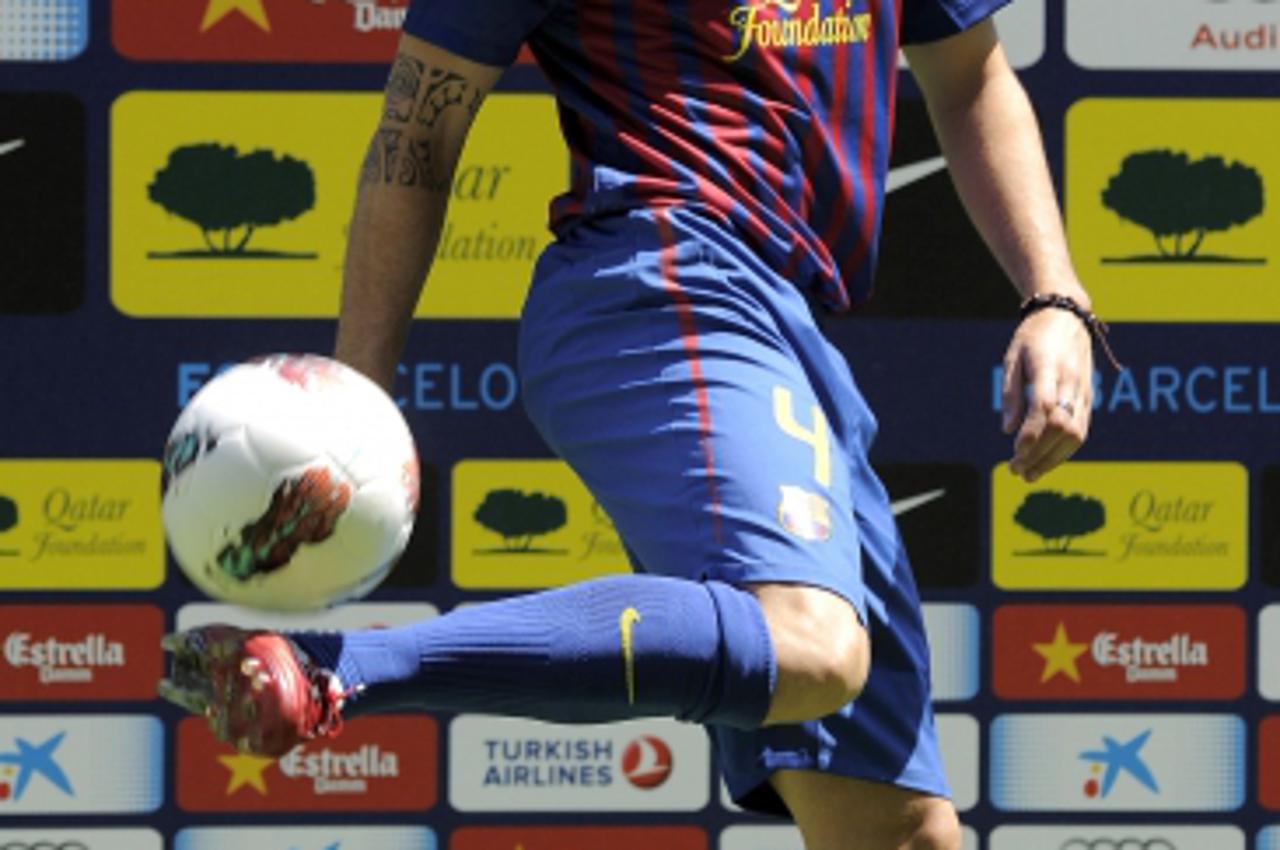 'Barcelona\'s new player Cesc Fabregas plays with a ball during his official presentation at the Camp Nou\'s stadium in Barcelona, after signing a new contract with the Catalan club, on August 15, 201