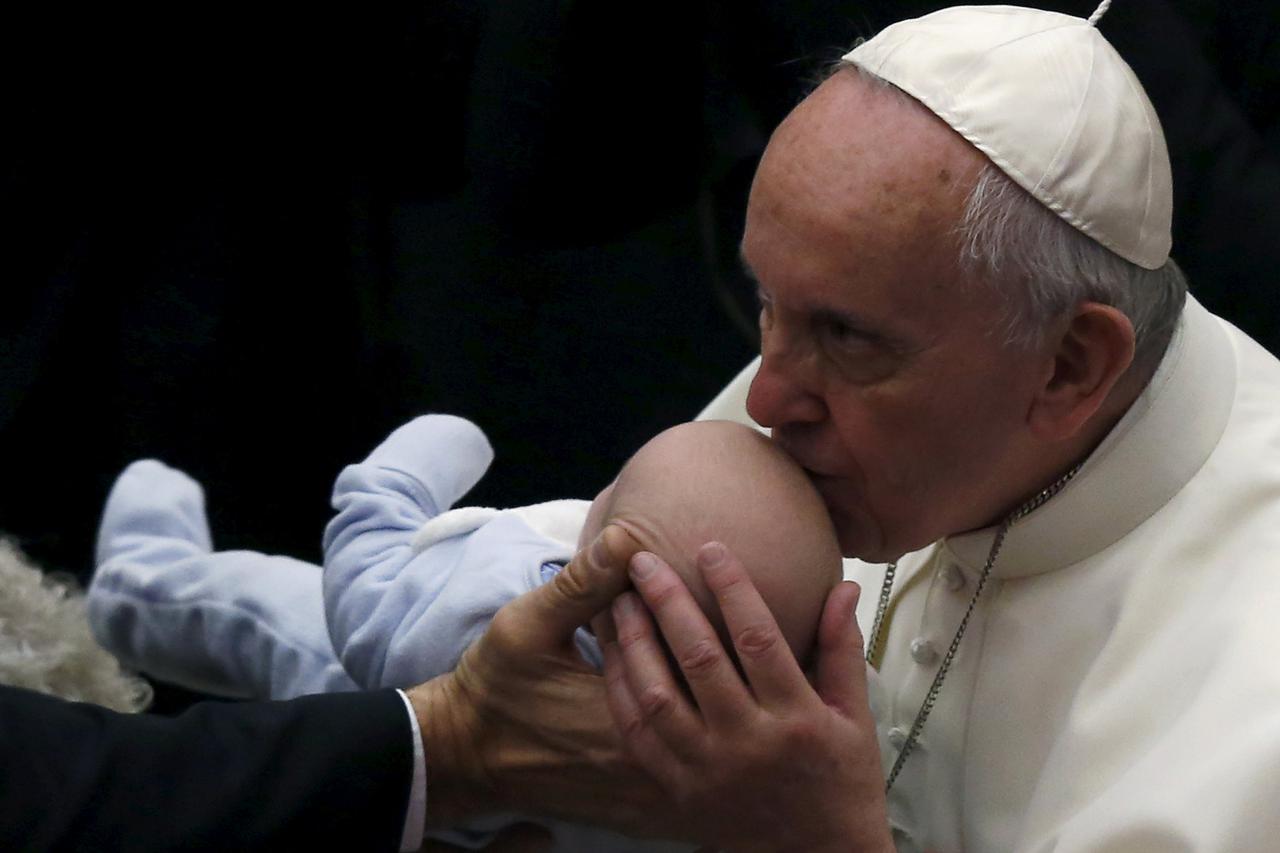Pope Francis (R) kisses a baby during a special audience with Roman Sinti community at the Paul VI hall at the Vatican, October 26, 2015. Pope Francis condemned xenophobia and discrimination against Europe's gypsies on Monday but said they also must do th