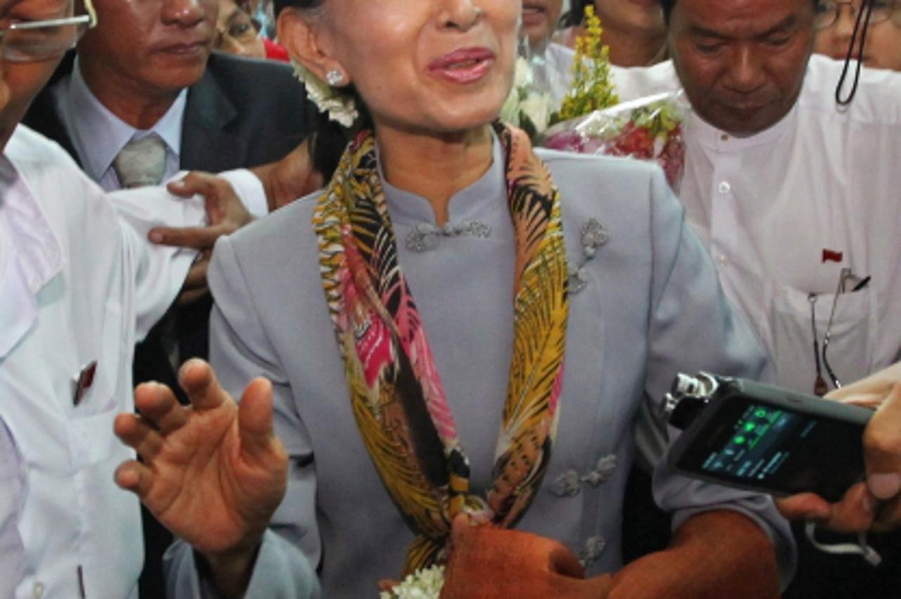 'Myanmar opposition leader Aung San Suu Kyi is surrounded by media representatives ahead of her departure at Yangon International Airport on June 13, 2012. Democracy icon Aung San Suu Kyi left Myanmar