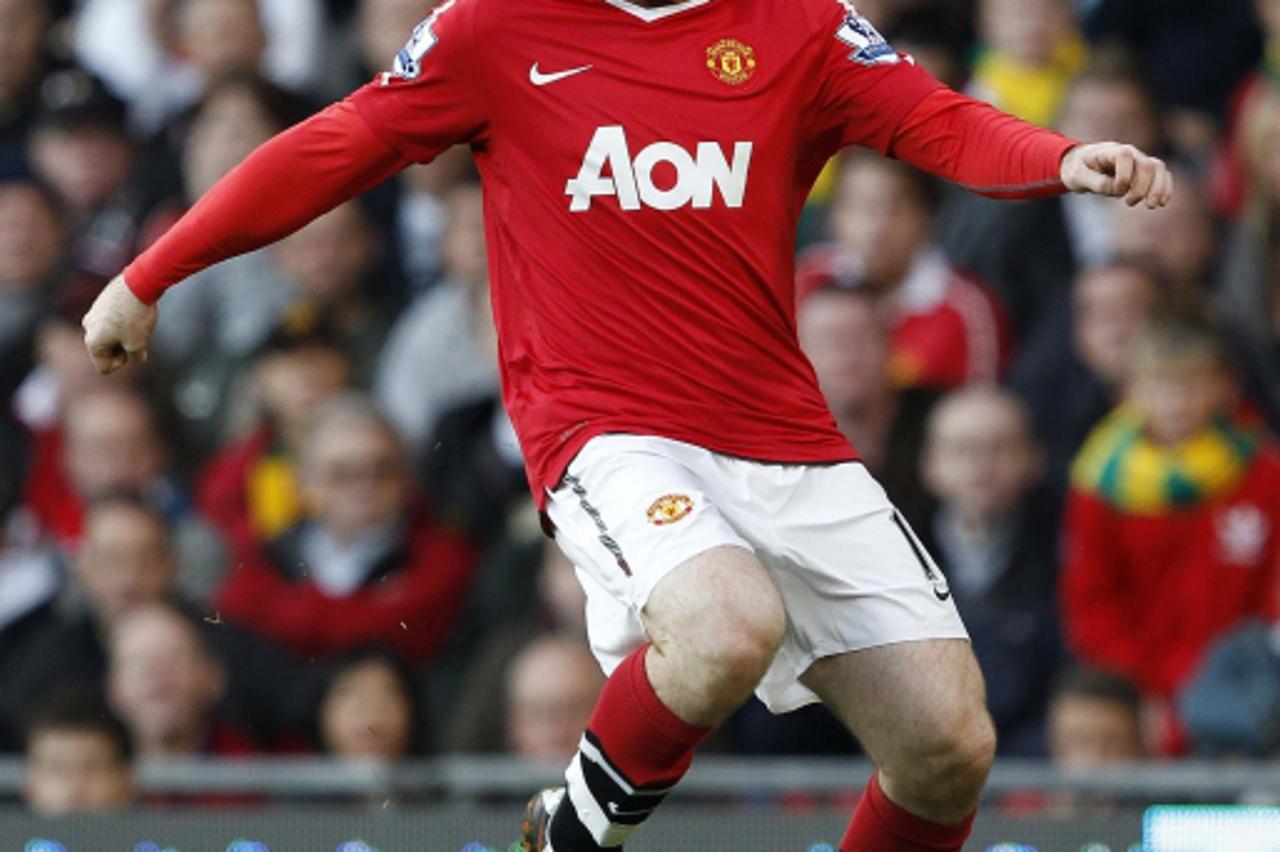 \'Manchester United\'s Wayne Rooney runs with the ball during their English Premier League soccer match against West Bromwich Albion at Old Trafford in Manchester, northern England, October 16, 2010. 