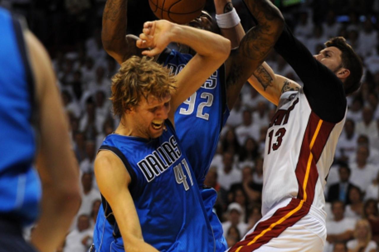 'Dirk Nowitzki (L) and DeShawn Stevenson (C) of the Dallas Mavericks grapple for a rebound against Corey Brewer (R) of the Miami Heat during Game 1 of the NBA Finals on May 31, 2011 at the AmericanAir