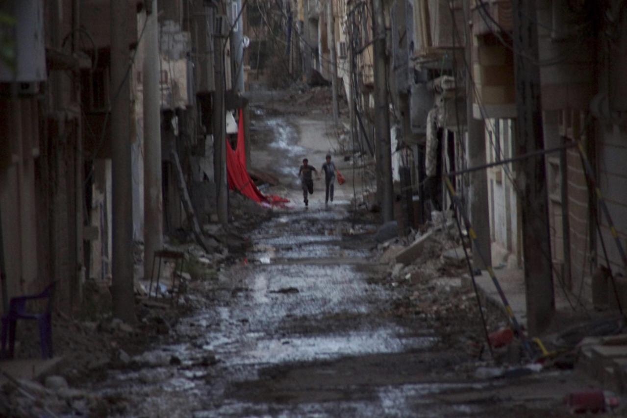 'People run down a street in Deir al-Zor, May 18, 2013. Picture taken May 18, 2013. REUTERS/Khalil Ashawi (SYRIA - Tags: POLITICS CIVIL UNREST CONFLICT TPX IMAGES OF THE DAY)'