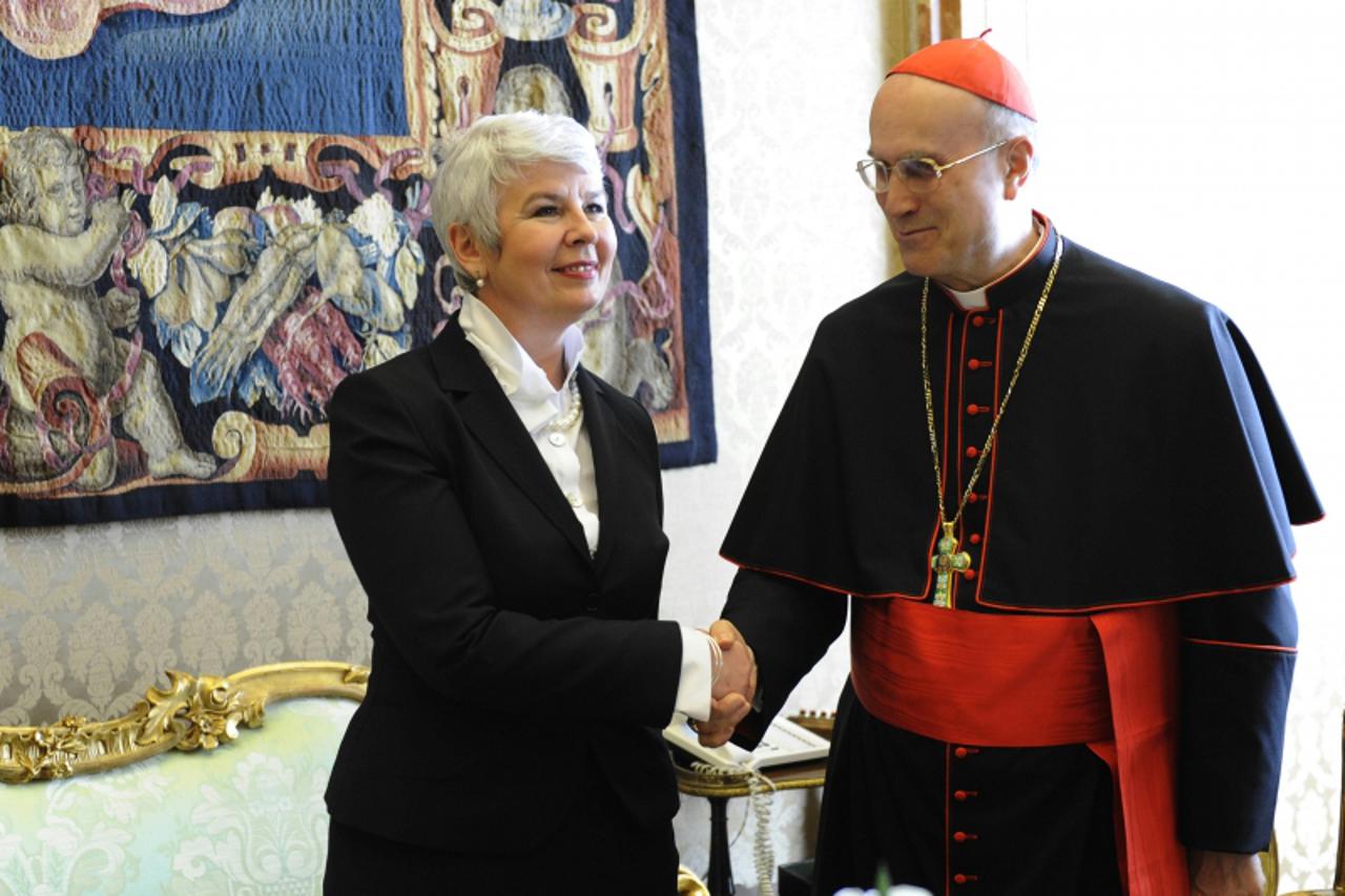 'Croatian Prime Minister Jadranka Kosor (L) shakes hands with Vatican state secretary, Cardinal Tarcisio Bertone, during an audience at the Vatican on March 13, 2010.   AFP PHOTO / POOL / DANILO SCHIA