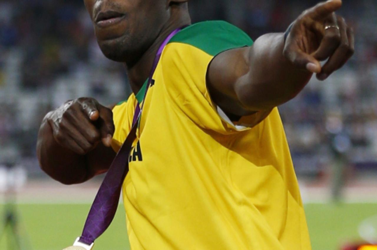 'Jamaica\'s Usain Bolt poses with his gold medal at the men\'s 200m victory ceremony during the London 2012 Olympic Games at the Olympic Stadium August 9, 2012. REUTERS/Eddie Keogh (BRITAIN  - Tags: S