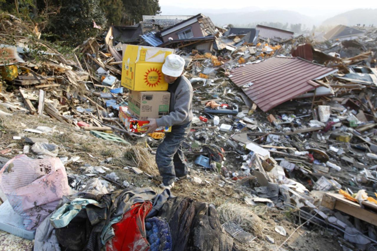 \'A man salvages possessions from the rubble in Rikuzentakata, northern Japan after the magnitude 8.9 earthquake and tsunami struck the area, March 13, 2011. Broadcaster NHK, quoting a police official