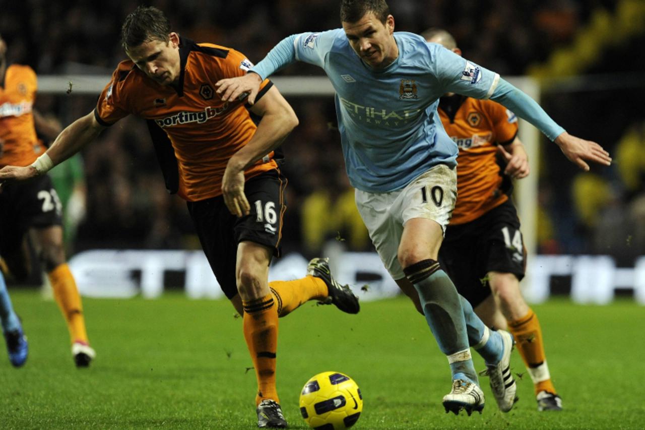 \'Manchester City\'s Edin Dzeko (R) challenges Wolverhampton Wanderers\' Christophe Berra during their English Premier League soccer match in Manchester, northern England January 15, 2011. REUTERS/Nig