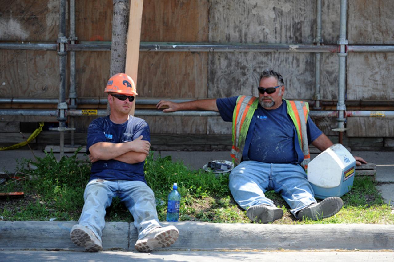 RAM Conrtuction Services workers Kevin Hamm, Howell, and Joseph Zucca, Westland, rest in the shade during their lunch break on Wednesday. Zucca attempts to stay cool by drinking lots of fluids. Melanie Maxwell I AnnArbor.com