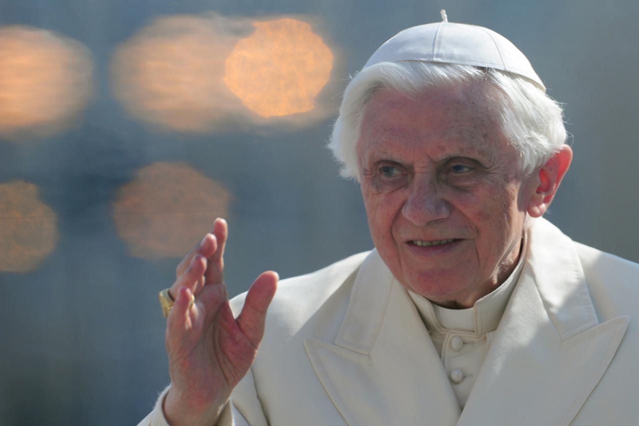 \'Pope Benedict XVI waves from behind the protective window of his papamobile as he arrives for his weekly general audience on March 7, 2012 at St Peter\'s square at the Vatican.  AFP PHOTO / VINCENZO