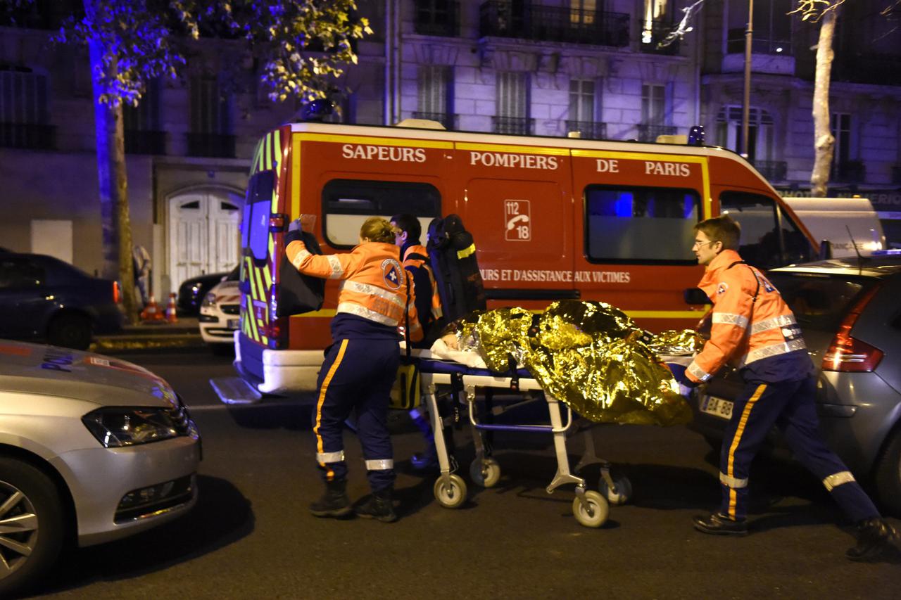 Rescuers evacuate an injured person on Boulevard des Filles du Calvaire, close to the Bataclan concert hall in central Paris, early on November 14, 2015. A number of people were killed in an 