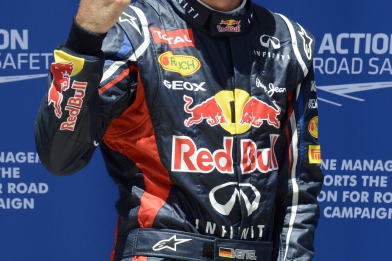 'Red Bull Racing\'s German driver Sebastian Vettel celebrates in the parc ferme at the Valencia Street Circuit on June 23, 2012 in Valencia after the qualifying race of the European Formula One Grand 